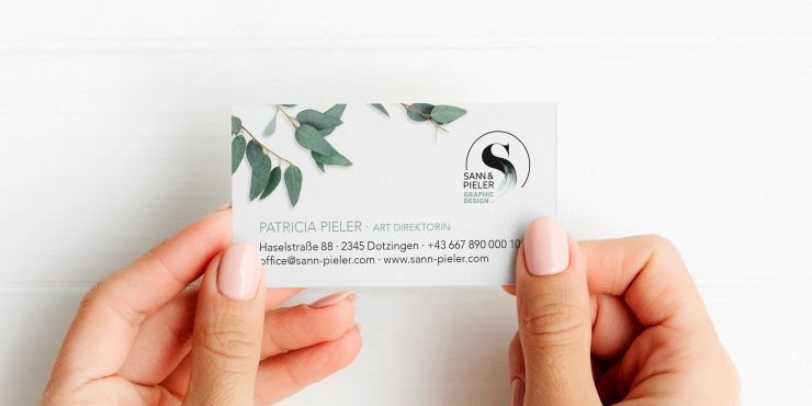 Zwei Hände halten eine Standard-Visitenkarte aus Volumenkarton