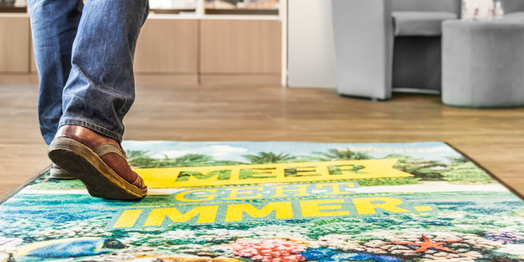 Große bedruckte Fußmatte bei Eingangstüre