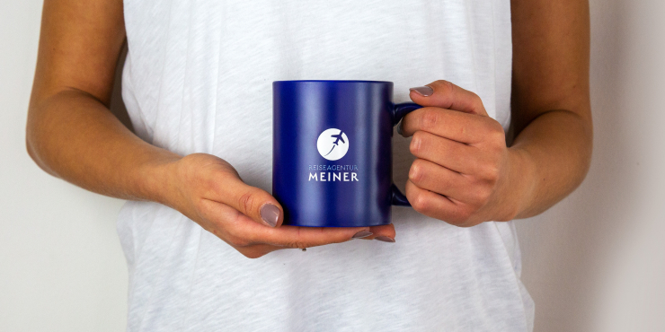 Jemand hält eine Tasse mit Gravur
