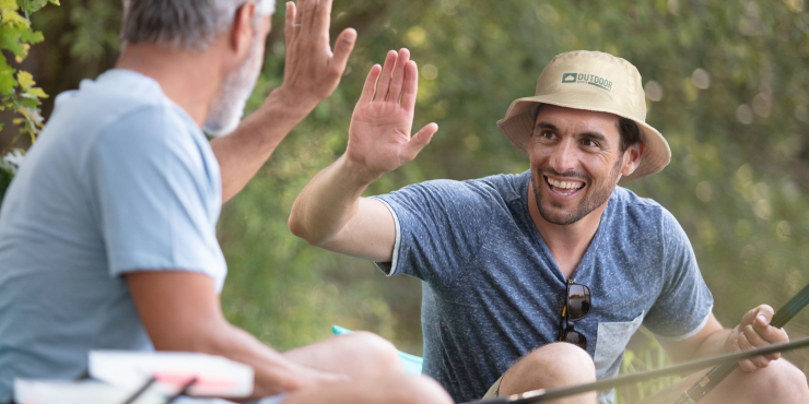 Individuell bedruckter Anglerhut auf Mann der anderen Mann Hand einschlägt