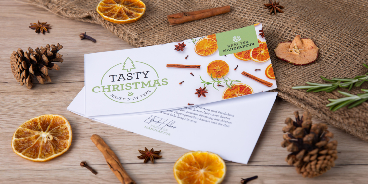 Weihnachtskarte mit Orangen und Zimtstangen im Hintergrund
