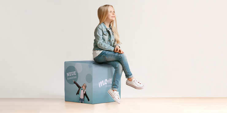 Mädchen sitzt auf Sitzwürfel aus Schaumstoff