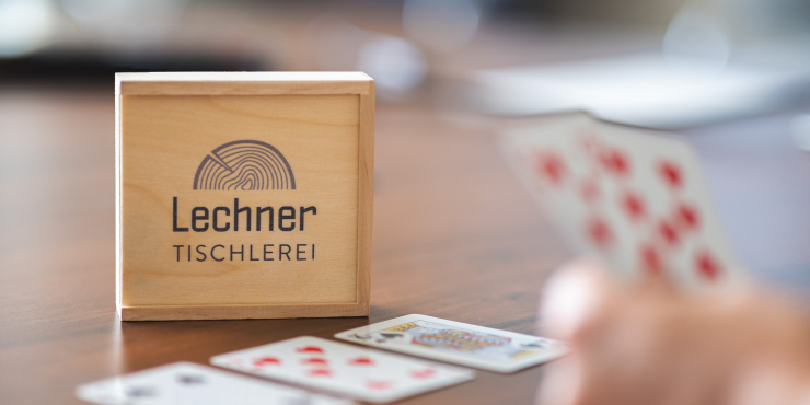 Individuell bedrucktes Karten- und Würfelset Hand mit Spielkarten auf Tisch