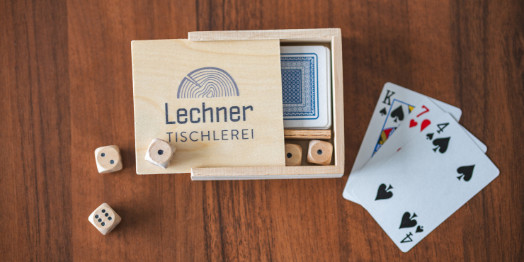 Individuell bedrucktes Karten- und Würfelset Hand mit Spielkarten und Würfel auf Tisch