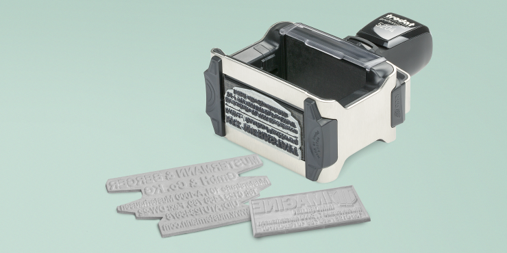 Textplatten und ein Stempel auf türkisem Hintergrund