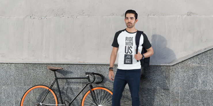 Mann steht neben Fahrrad und trägt individuell bedrucktes basic T-Shirt