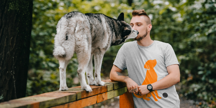 Junger Mann trägt bedrucktes basic T-Shirt neben seinem Hund