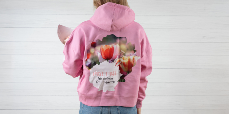 Mädchen trägt rosafarbenen Stanley/Stella-Hoodie mit Aufdruck am Rücken