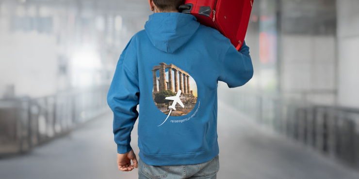Mann trägt einen geöffneten Koffer und hat einen blauen Stanley/Stella-Hoodie mit Aufdruck auf dem Rücken an
