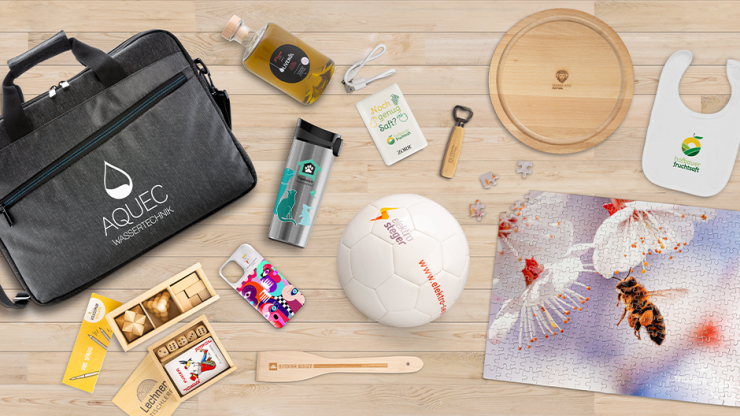 Verschiedene bedruckte Werbeartikel auf hölzernem Hintergrund