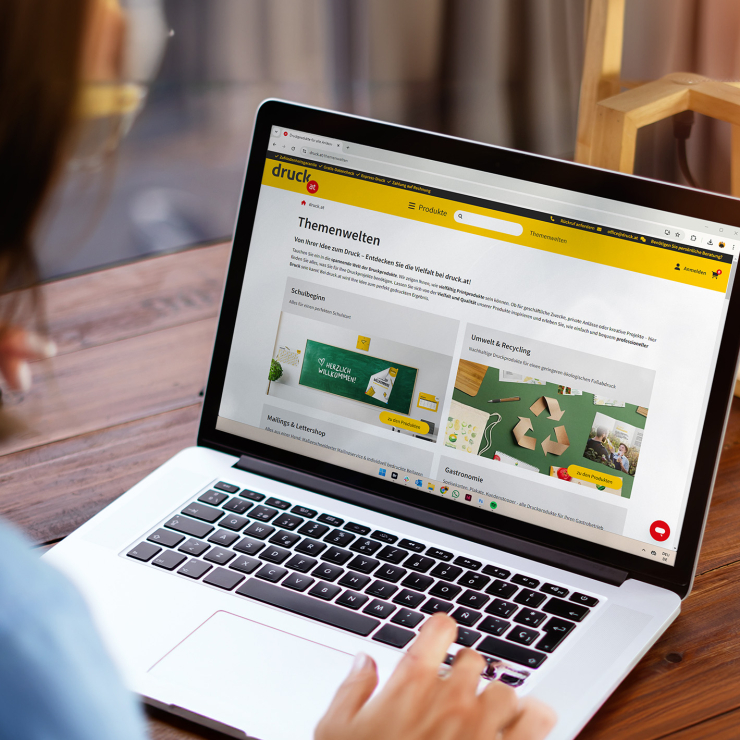 Frau die vor Laptop sitzt und eine Website offen hat