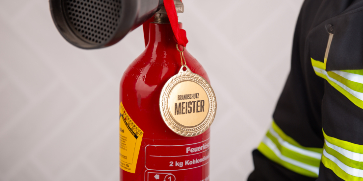 Medaille an einem Feuerlöscher aufgehangen