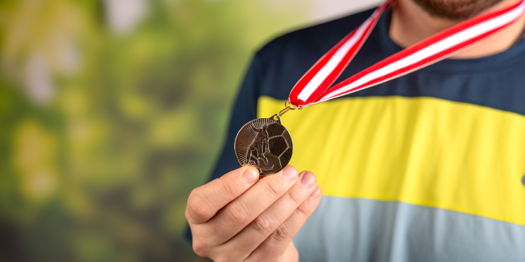 Jemand hält Medaille in die Kamera
