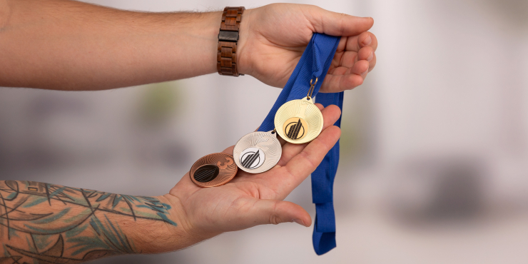 Jemand hält eine Medaillenserie in der Hand