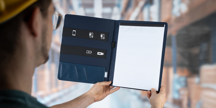 Person mit gelben Helm hält geöffneten personalisierten A4-Organizer in die Höhe