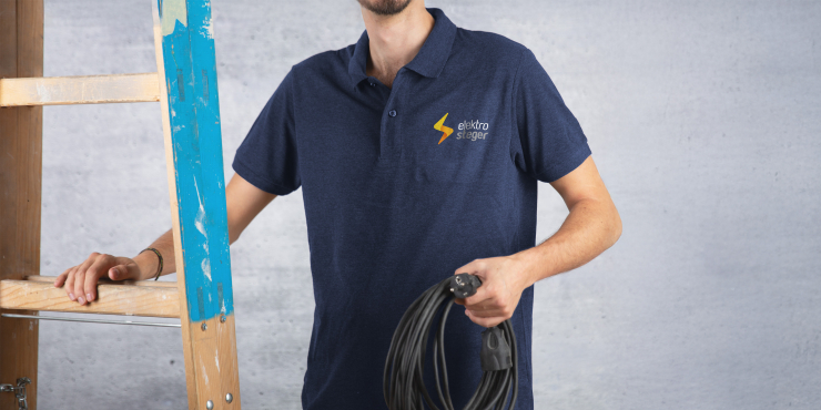 Mann hält sich an einer Leiter fest und hält ein Verlängerungskabel