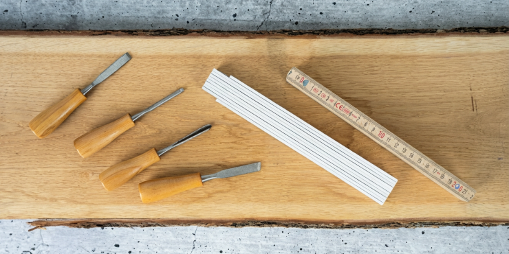 Unbedruckte Zollstoecke auf Holzplatte liegend