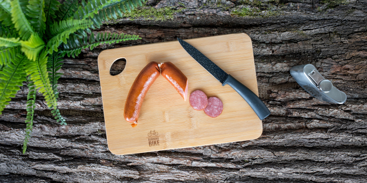 Aufgeschnittener Wurst auf einem Schneidebrett aus Holz mit Loch
