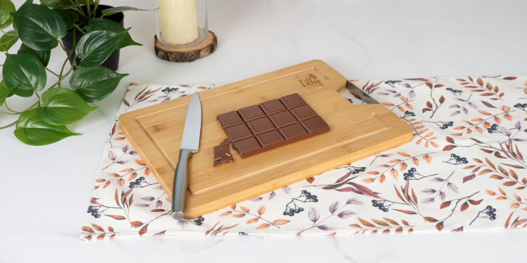 Schokoladentafel auf einem hölzernen Schneidebrett mit Mitallgriff