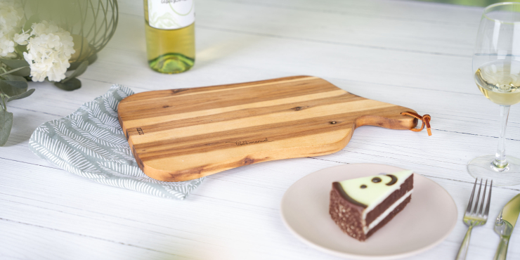 Schneide- und Servierbrett in natürlicher Holzform liegt auf einem Tisch 