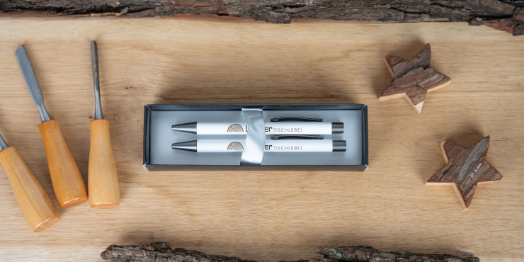Bowie Schreibset mit individuellem Design liegt neben Holzwerkzeug auf einem Holzbrett