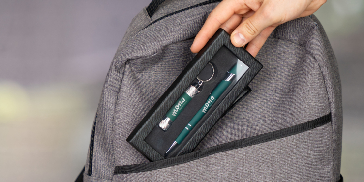 Person gibt das Schreibset Ellipse &amp; Chroma Soft Touch in einer edlen Schachtel in einen grauen Rucksack