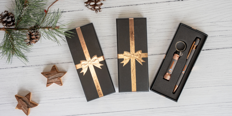 Person hält Ellipse &amp; Chroma Soft Touch Ribbon mit personalisiertem Design und in einer edlen Schachtel