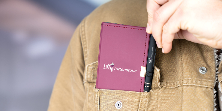 Person steckt sich das personalisierte Schreibset in die Brusttasche