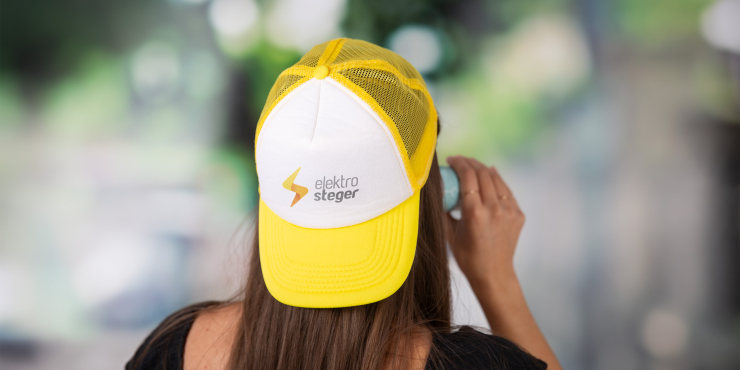 Eine Frau trägt einen individuell bedruckte Truckerkappe