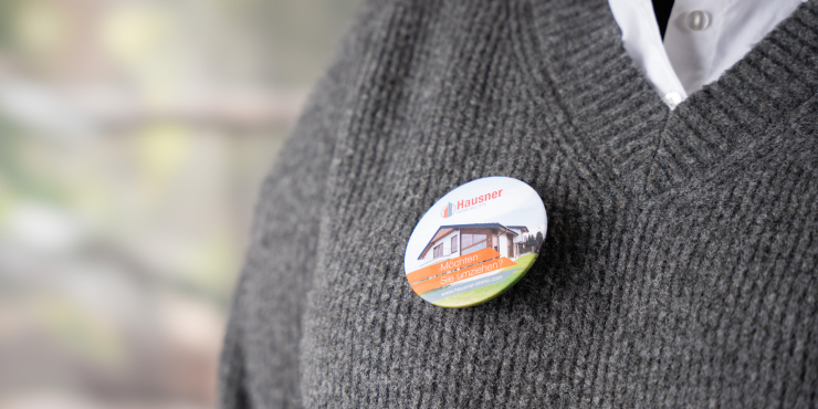 Personalisierter Kleidungsmagnet mit eigenem Logo auf einem grauen Pullover