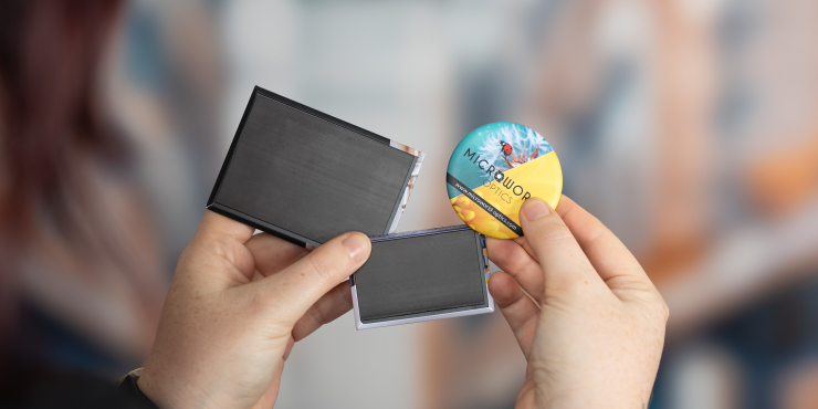 Eine Person hält drei verschiedene Magneten mit personalisiertem Motiv und in unterschiedlichen Formen in den Händen