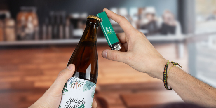 Person öffnet eine Flasche in einem Lokal mit einem Flaschenöffner-Feuerzeug