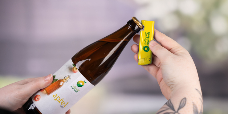 Person öffnet eine Flasche mit einem individuellen Flaschenöffner-Feuerzeug