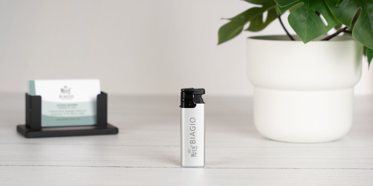 Go Turbo Feuerzeug steht auf einem schlichten Tisch mit Visitenkarten und einer Pflanze