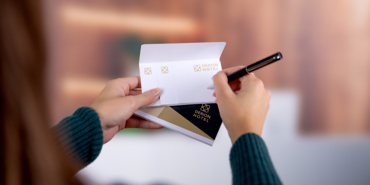 Person hält Haftnotizen in der Hand und notiert sich etwas in einem Hotel