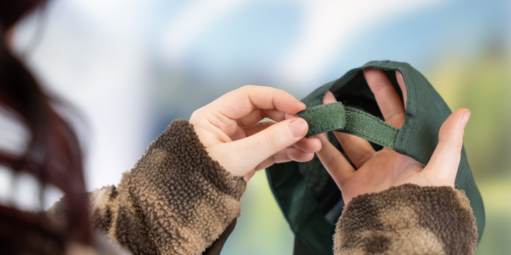 Eine Person öffnet den Verschluss einer individuell bedruckten Kappe