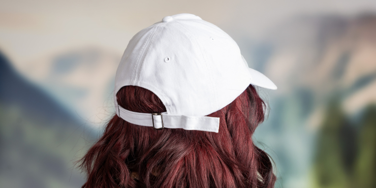 Eine Person mit roten Haaren trägt eine individuell bedruckte Kappe