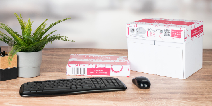 Kopierpapier Premium steht auf einem Bürotisch neben Pflanze, Tastatur und Computermaus