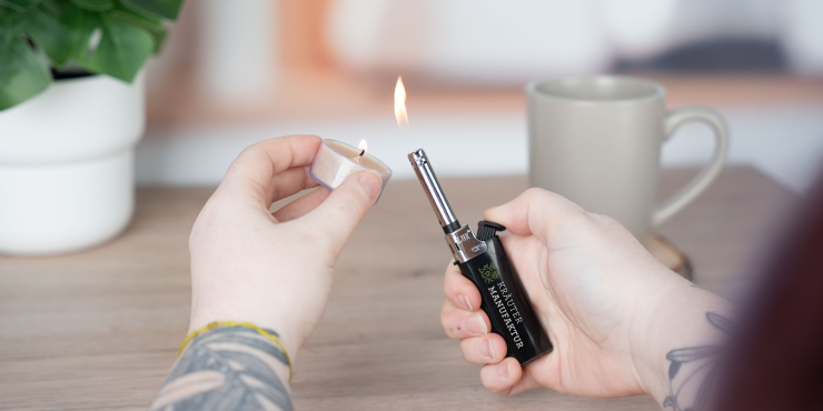 Person zündet eine Kerze mit dem LUX Candlelite Viva Feuerzeug an
