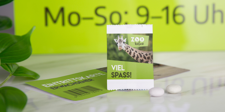 Individuell bedrucktes Flowpack, daneben Pfefferminz-Mentos und eine Broschüre
