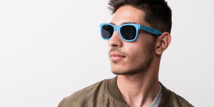 Mann trägt blaue Sonnenbrille mit Aufdruck