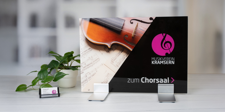 Personalisiertes Schild auf Standfüssen neben Pflanzen auf weissem Tisch