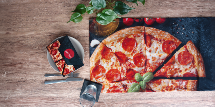 Recycling Tischläufer mit dem Druck einer Pizza auf einem gedeckten Tisch und einer Pflanze