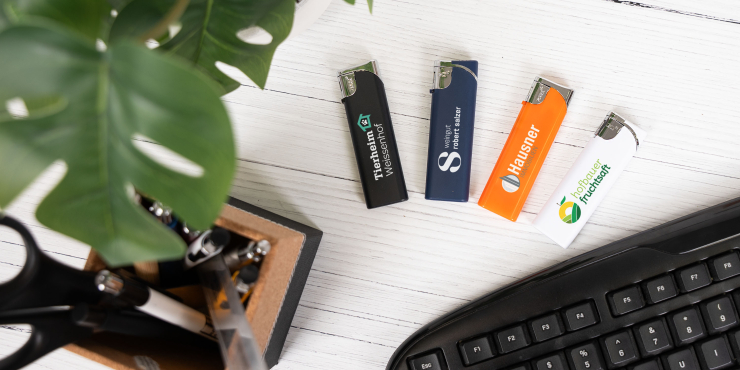 Diverse Elektro-Feuerzeuge liegen auf einem Bürotisch