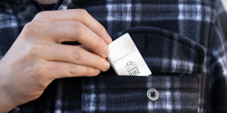 Person steckt das ZORR Benzin Feuerzeug in die Brusttasche