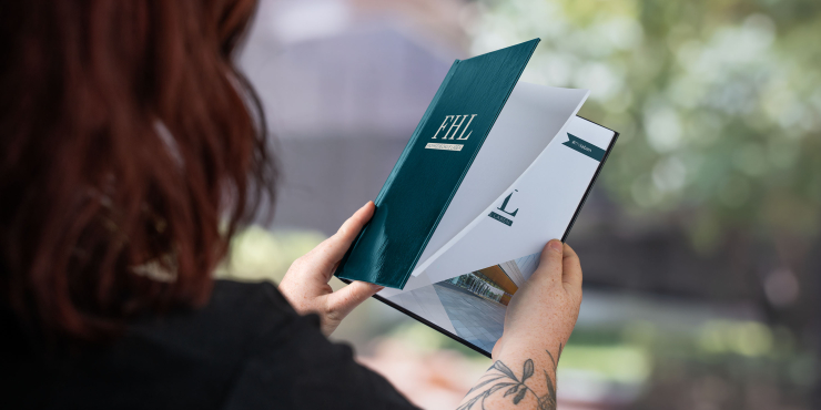 Bestpreis Hardcover mit Klebebindung in der Hand haltend und mit personalisiertem Cover