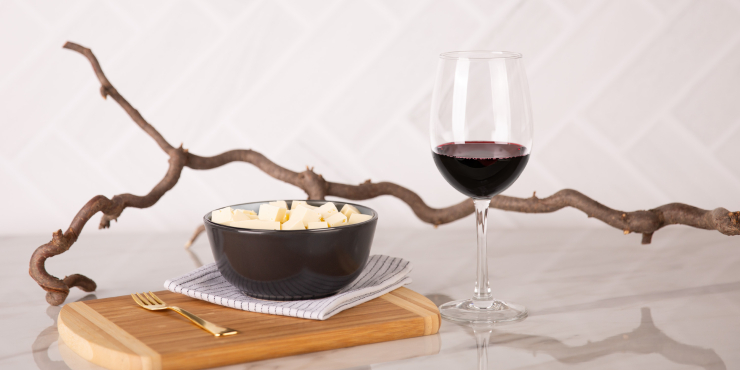 Ein Rotweinglas auf Mamor Hintergrund mit einem Suppenteller