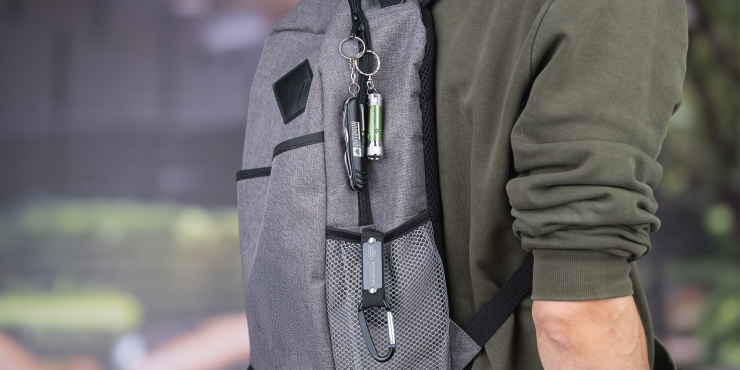 Auf einem Rucksack hängt ein Schlüsselanhänger mit Taschenlampe