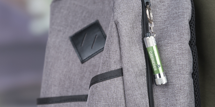 Eine bedruckte Taschenlampe mit Schlüsselring hängt an einem Rucksack