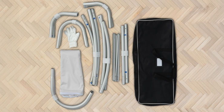Alle Teile des Zipper Banner Komplettsystems auf einem Holzboden